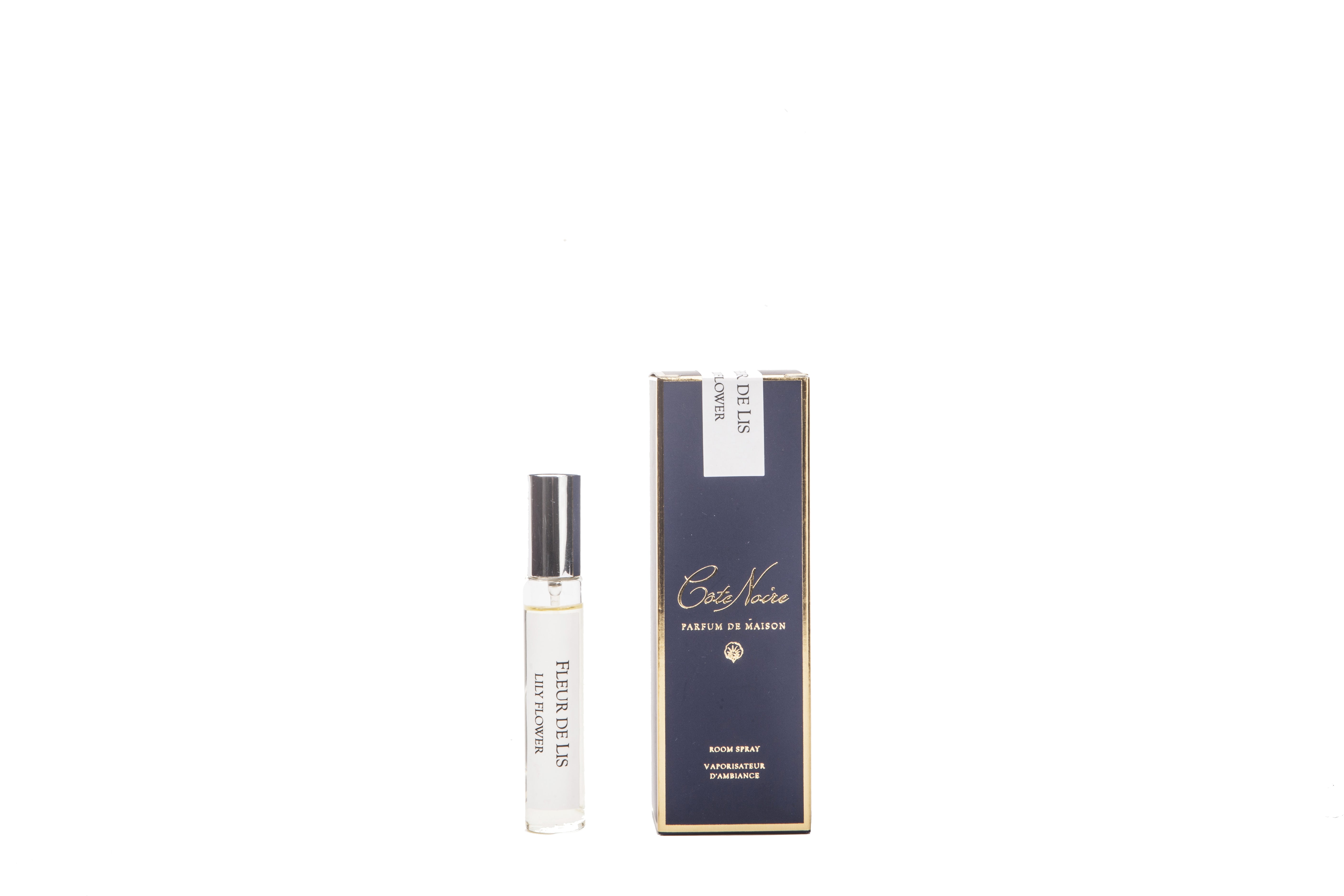 parfumflaeschchen mit silbernem deckel neben dunkler verpackung. weisser hintergrund. lily flower.