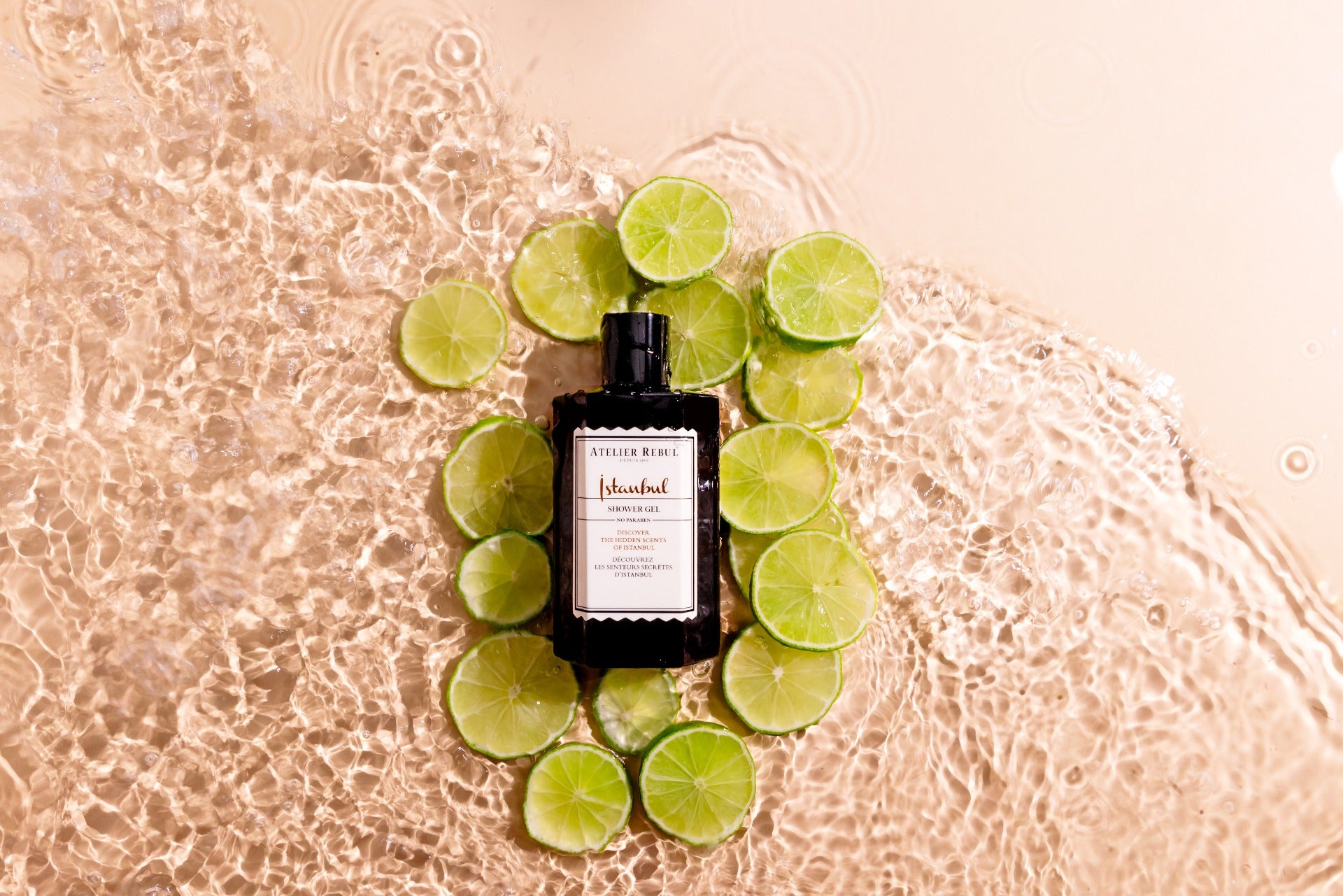 shower gel am strand liegend umkreist von limettenscheiben und in meerwasser. beigefarben