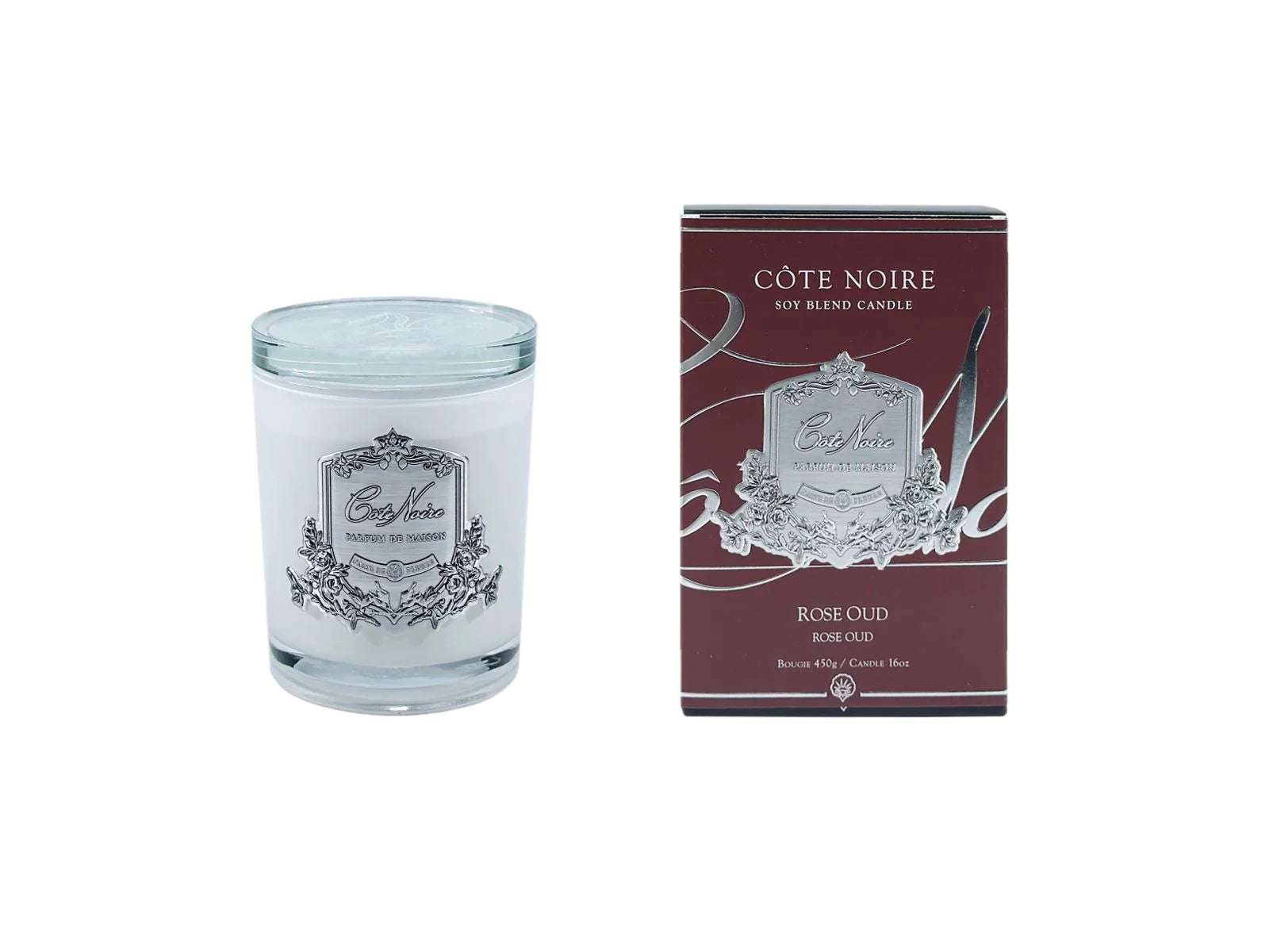 rose oud duftkerze in hellem glas mit glasdeckel neben dunkelroter verpackung vor weissem hintergrund.
