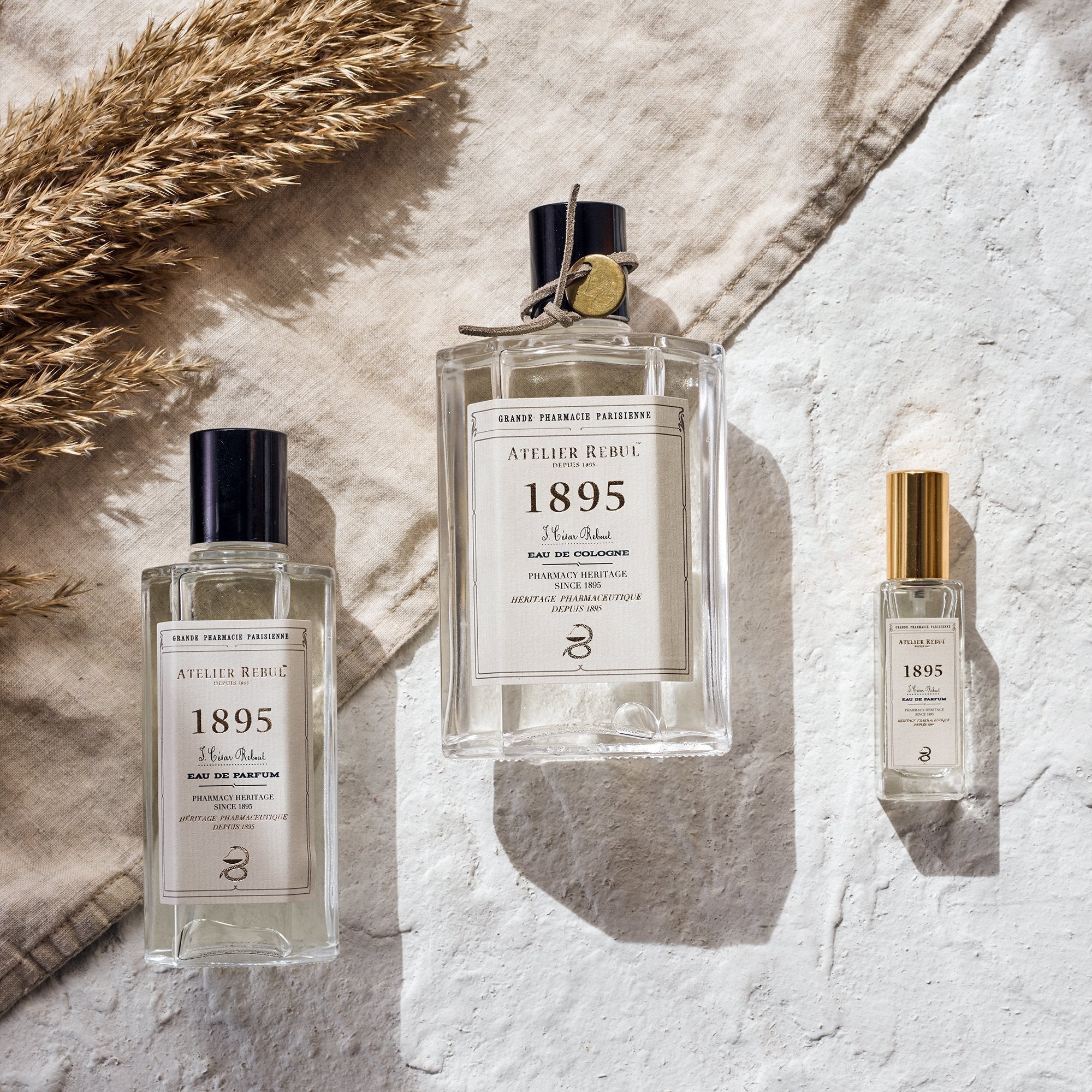 drei verschiedene groeßen 1895 parfumglasflaschen liegen auf dem boden