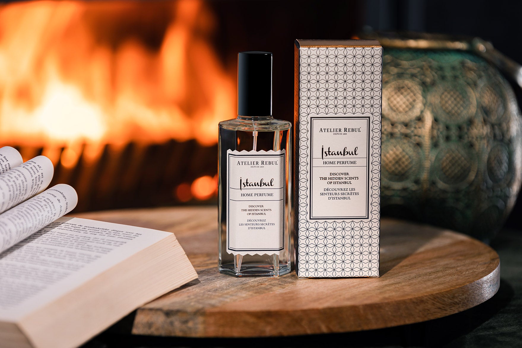 istanbul home parfum 125ml glasflasche neben der grau weiß gemusterten verpackung auf einem holzbrett mit dekorationen.