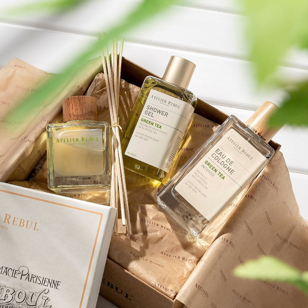 auf weißem holz liegt geöffnet die geschenkverpackung darauf liegen produkte von green tea atelier rebul