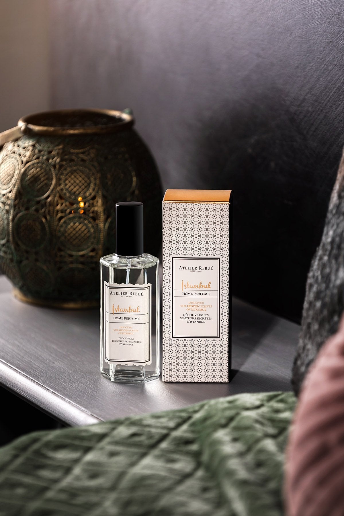 istanbul home parfum 125ml glasflasche neben der grau weiß gemusterten verpackung auf einem holzbrett mit dekorationen.
