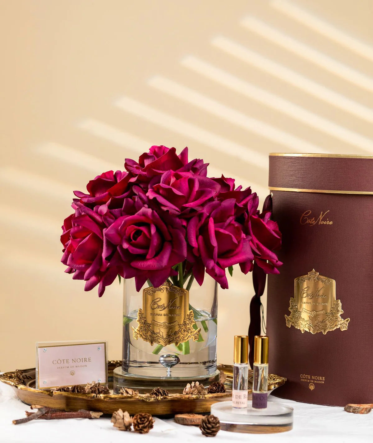 karminrote luxury grand bouquet duftblume mit weißen rosen auf holztablett mit kiefernzapfen.