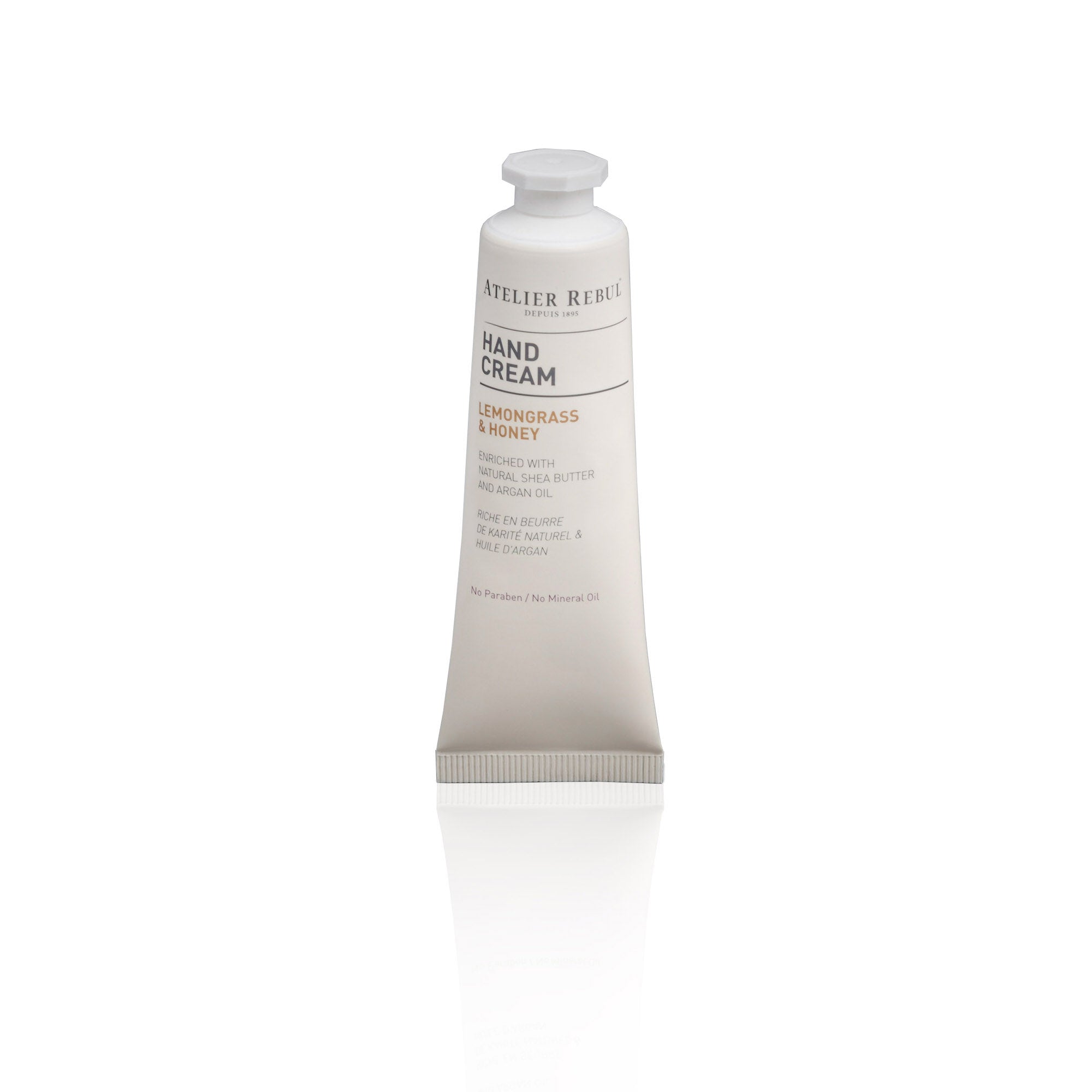 hinter weissem hintergrund steht die weisse handcreme tube mit drehverschluss im edlen design