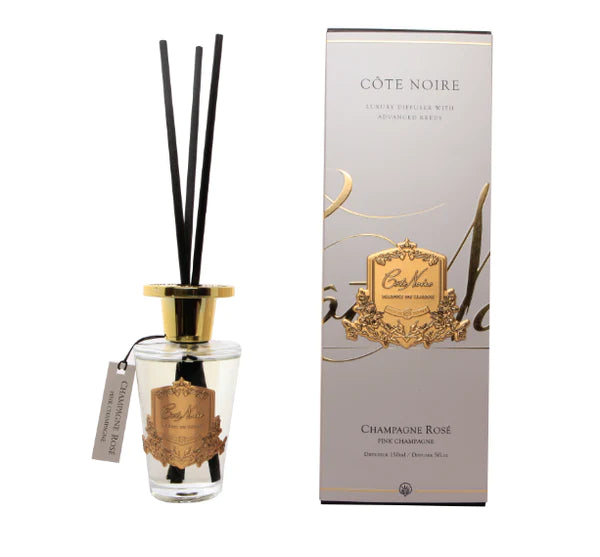 schwarze duftstaebchen im glas mit goldenem deckel und emblem. champagnerfarbene verpackung. pink champagne.