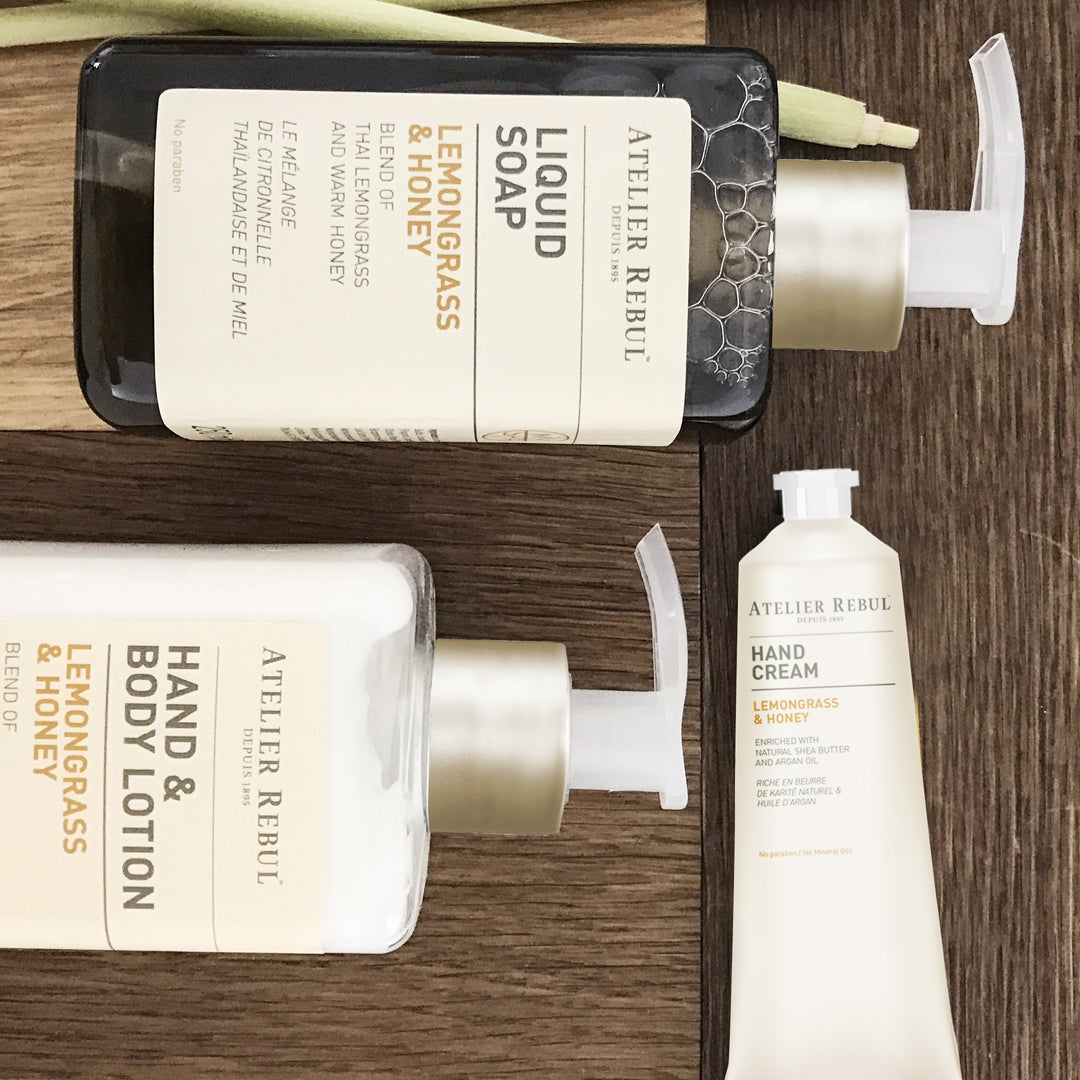 auf verschieden farbendem holz liegen akkorat 2 flaschen einmal mit lotion, einmal als seife und eine tube handcreme