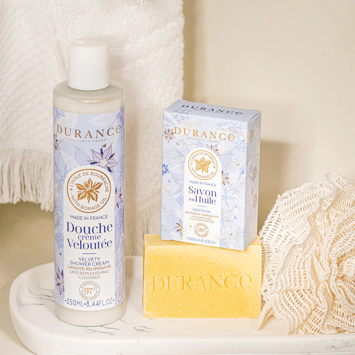 dekorativ stehen durance duschcreme seife mit verpackung nebeneinander hintergrund weisses handtuch
