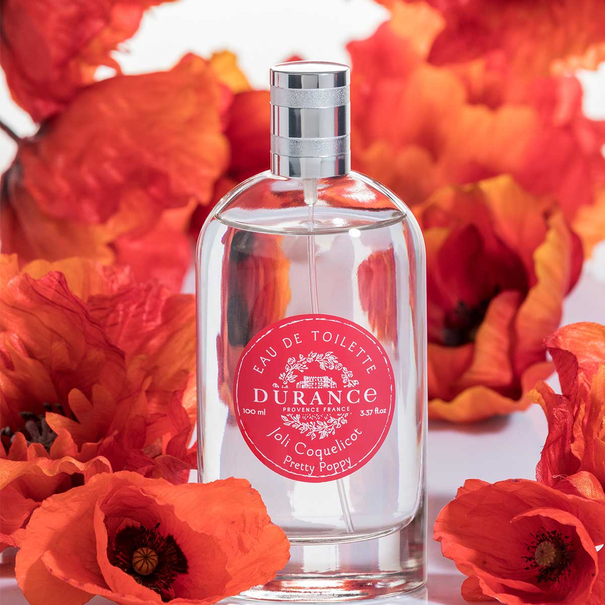 vor dem mohnbluetenbild steht eine Eau de toilette schoene mohnblueten glasspruehflasche