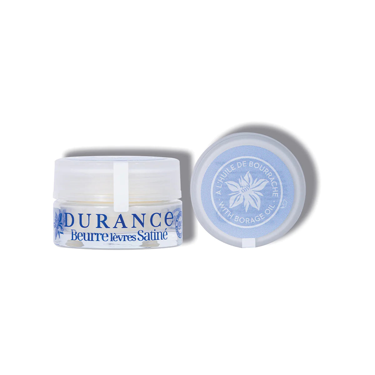 vor dem weissen hintergrund steht der dekorative cremetigel durance lippenbutter nebendran der deckel