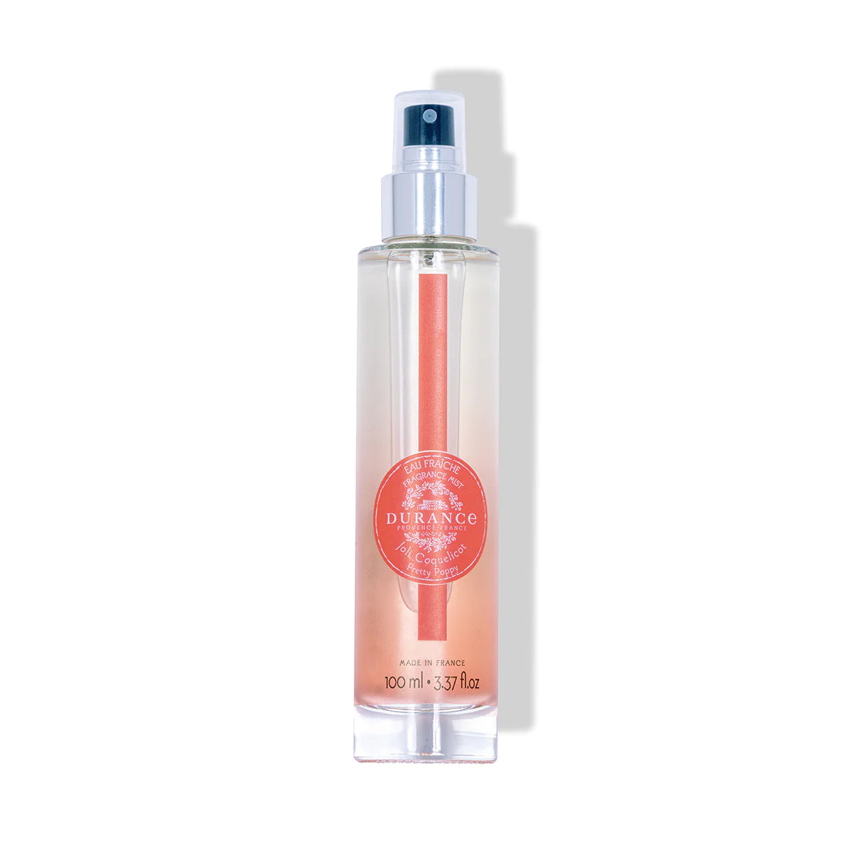 durchsichtige runde glasflasche eau fraiche schoene mohnbluete mit silbernen spruehkopf vor weissem hintergrund