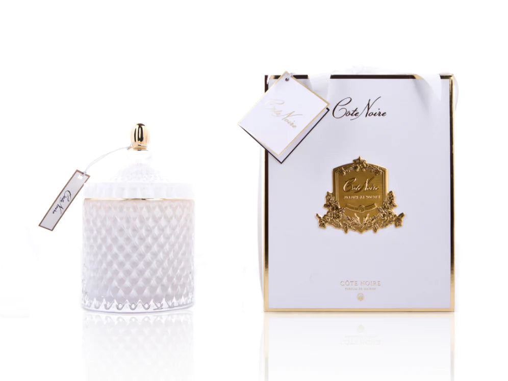 cote noire grand art duftkerze in dekorativem glas, daneben verpackung mit geschenkschleife, weiss und gold.