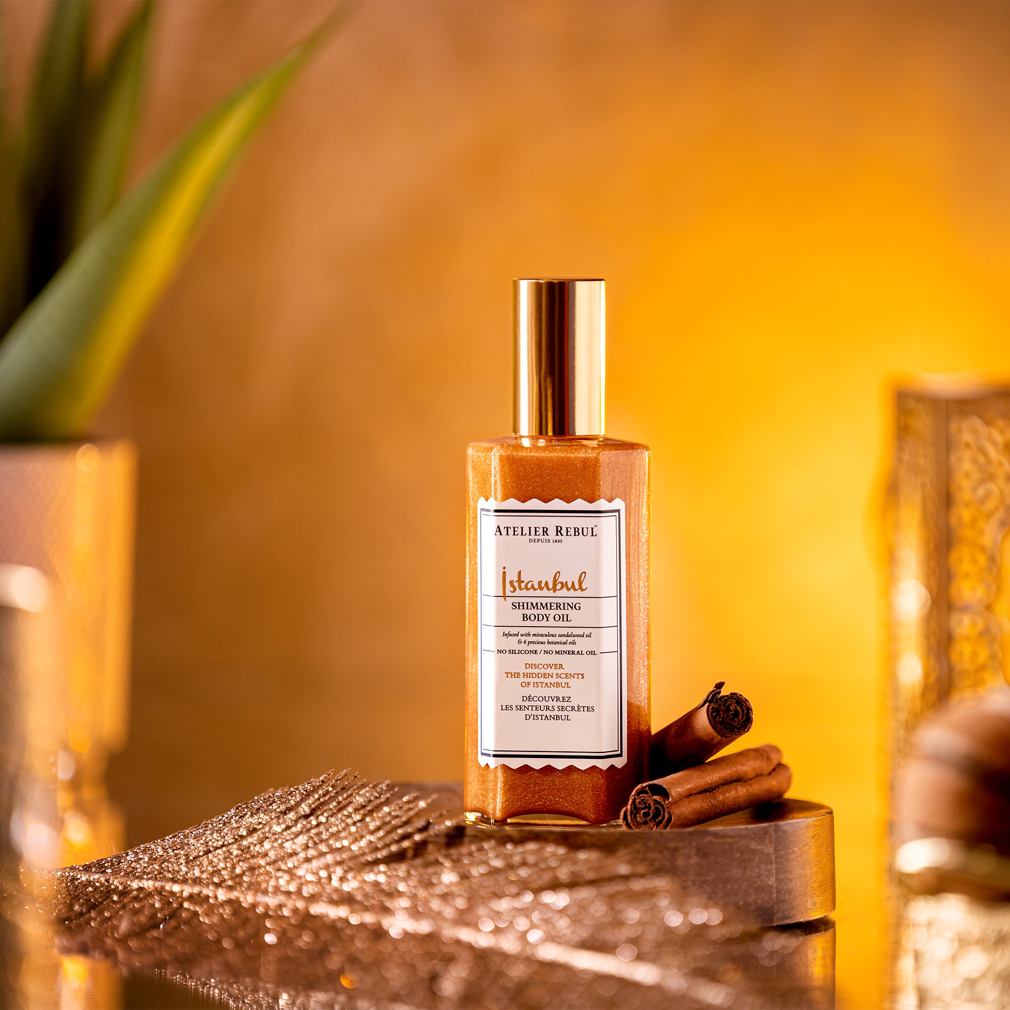 shimmering body oil mit goldenem deckel und inhalt auf rundem holzpodest. alles in goldbraun.