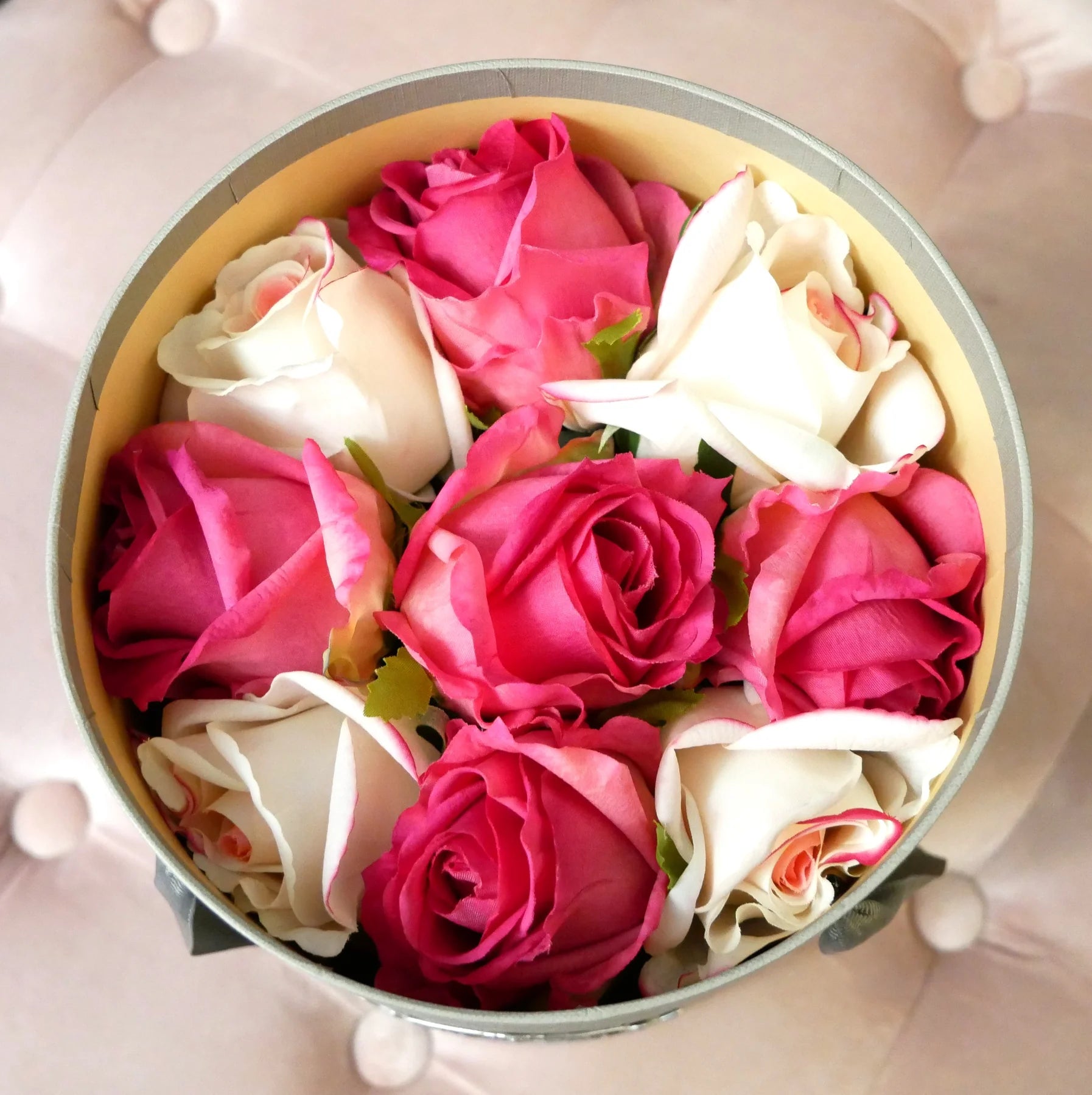vogelsicht auf rosa und weisse rosen in der geoeffneten geschenkbox. rosa hintergrund.