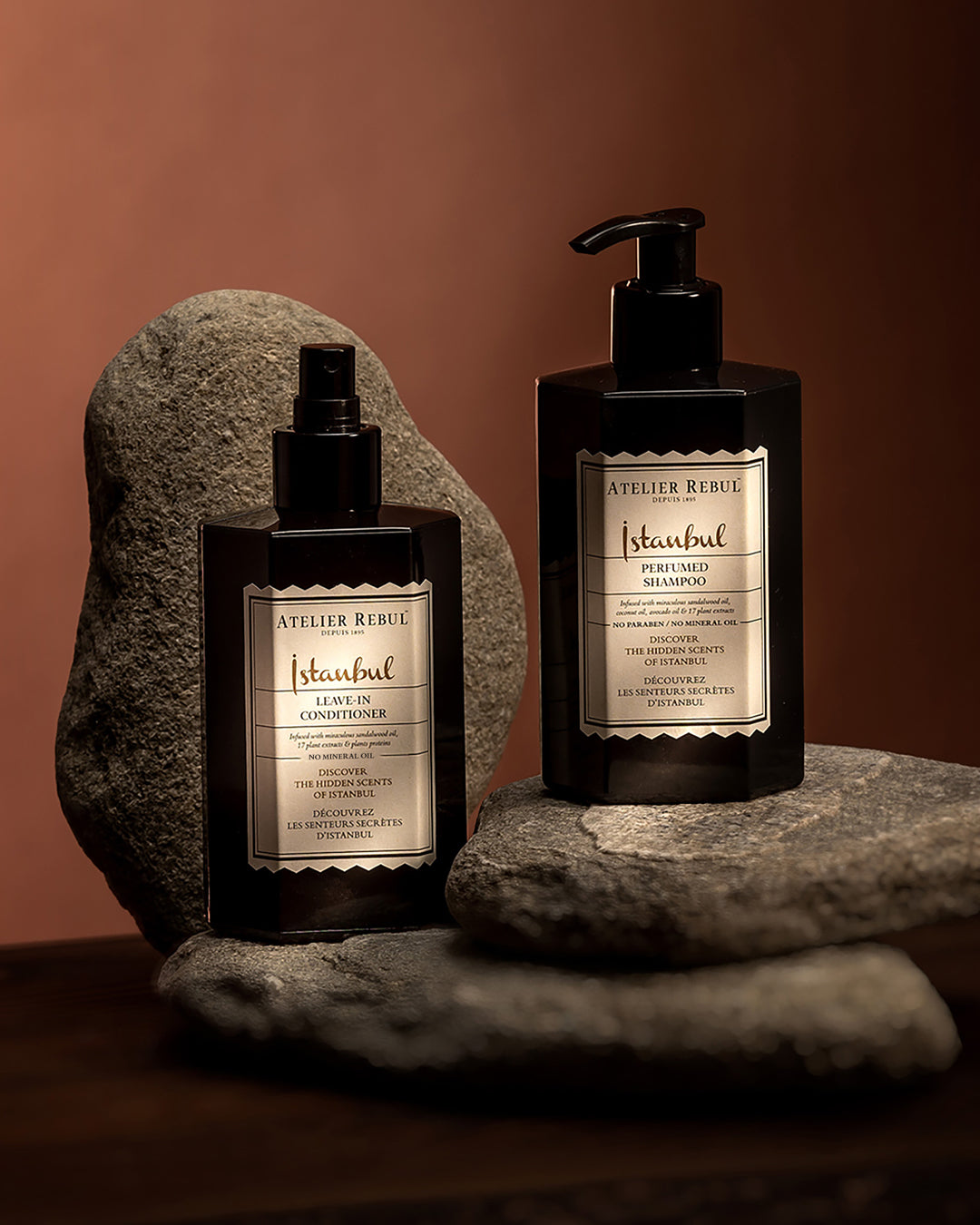 istanbul perfumed shampoo und leave in conditioner auf flach geformten steinen. brauner hintergrund.