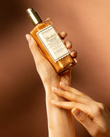 istanbul shimmering oil in einer weiblichen hand auf orangenem hintergrund.