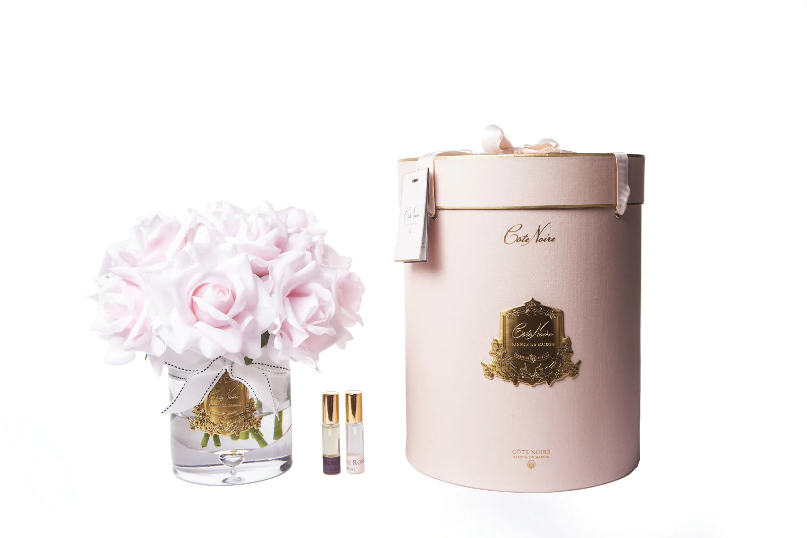13 rosa rosen arrangiert in einer edlen glasvase, zwei parfumsprays und eine luxurioese runde geschenkbox in rosa.