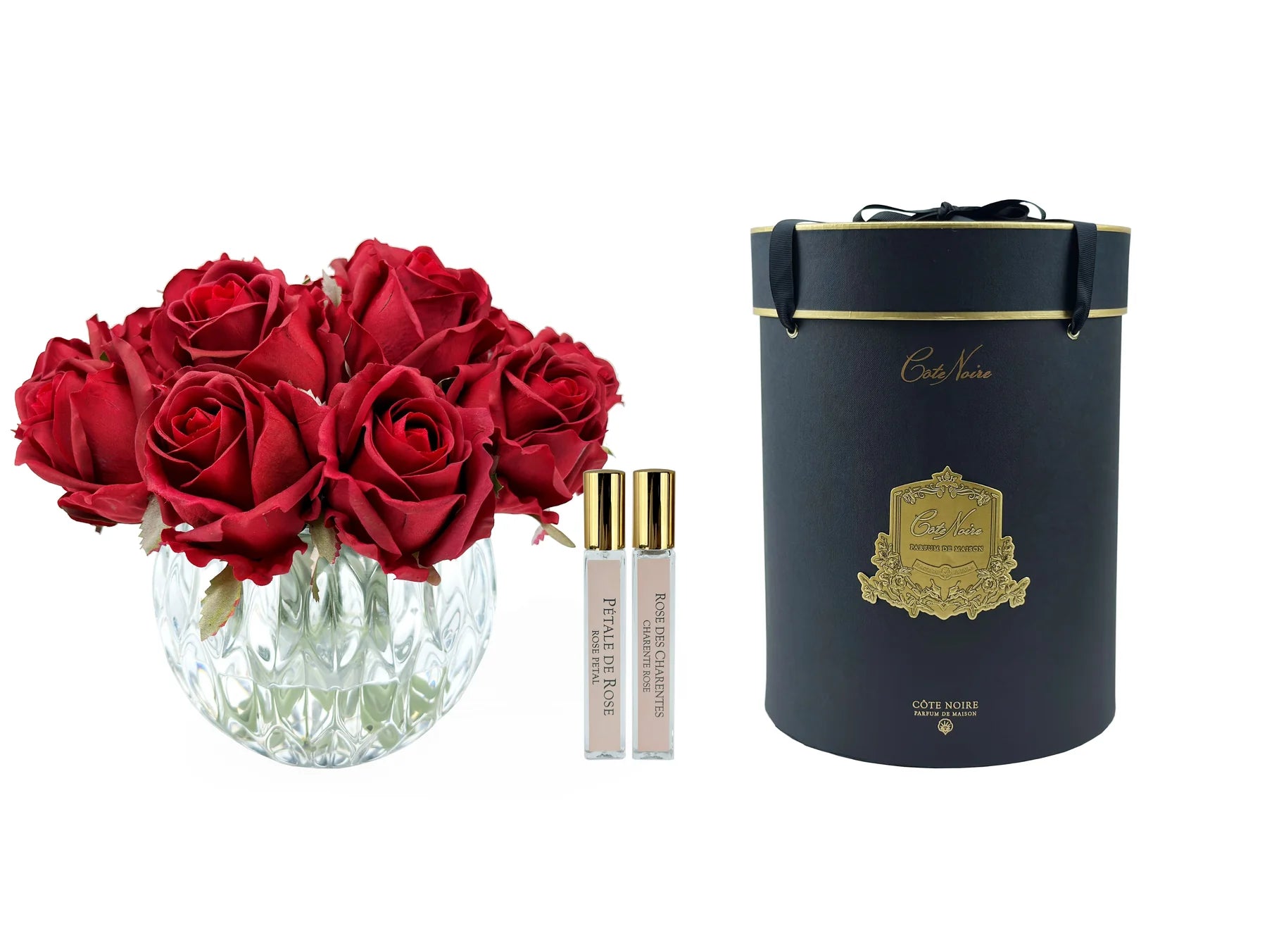 dreizehn rosen in rundem kristallglas, daneben zwei parfumsprays und schwarze geschenkbox