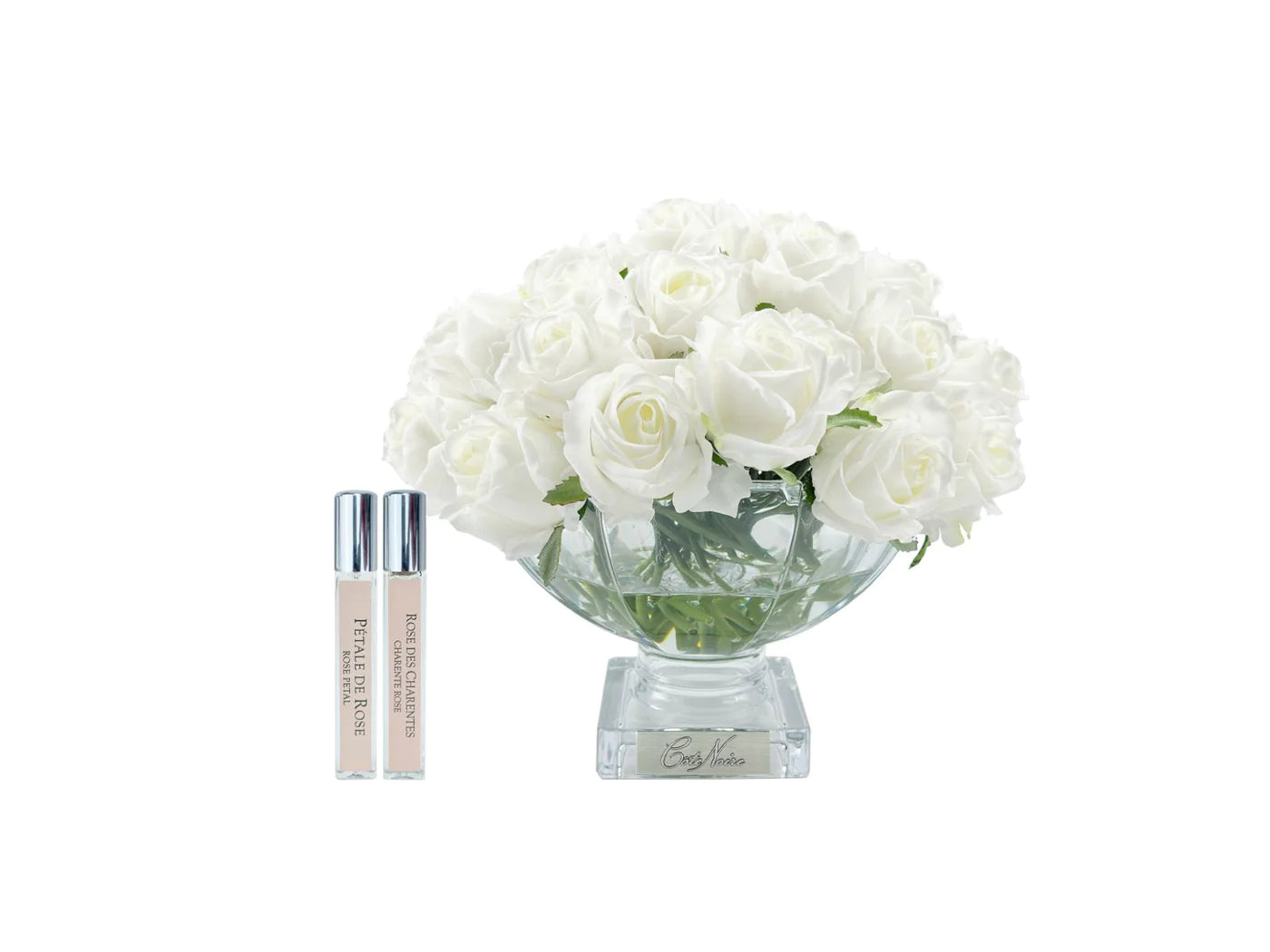 elfenbeinweisse rosen in nobler glasvase neben zwei parfumsprays. weisser hintergrund