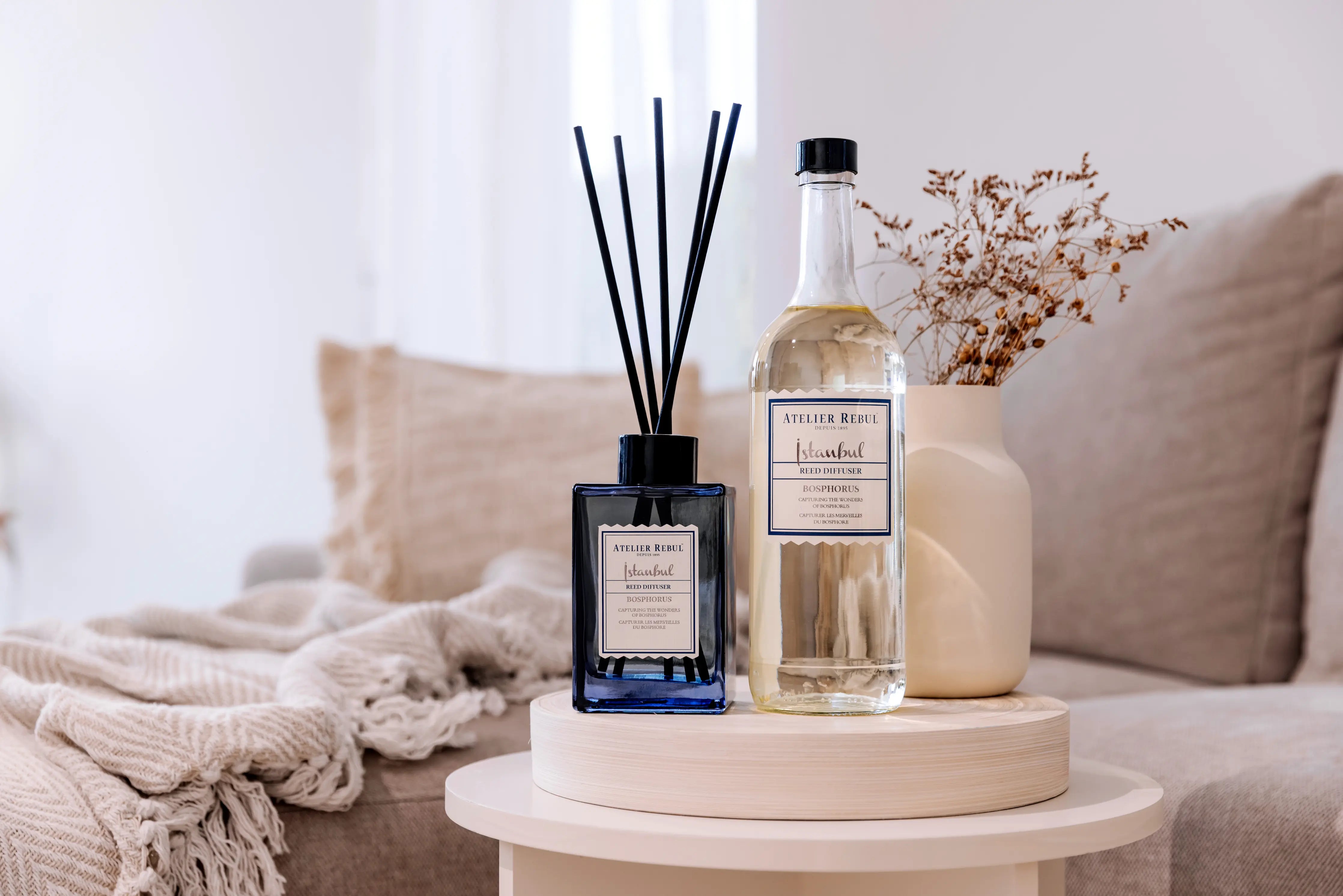 Atelier Rebul Istanbul Duftstäbchen Refill 985 ml – Nachfüllflasche für Raumduft „Bosphorus“, elegantes Wohnzimmer-Setting mit Diffuser und Flasche auf Beistelltisch.