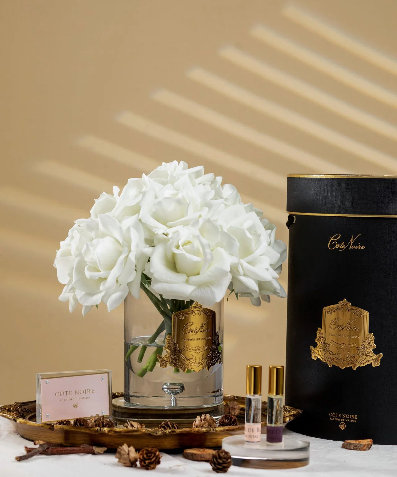 Eleganter Duftrosenstrauß in Elfenbeinweiß mit goldener Verzierung in luxuriöser schwarzer Geschenkbox – stilvoll arrangiert im warmen Licht.