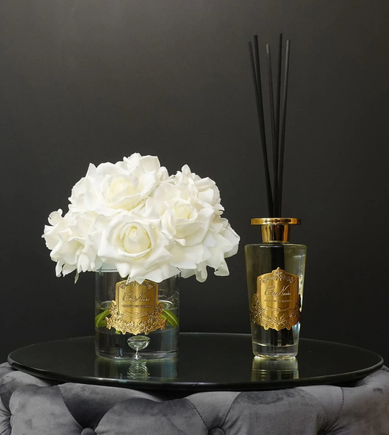 Duftendes Ensemble aus Rosenstrauß und Raumduft-Diffuser – Côte Noire in klassischem Schwarz-Gold auf schwarzem Hintergrund.