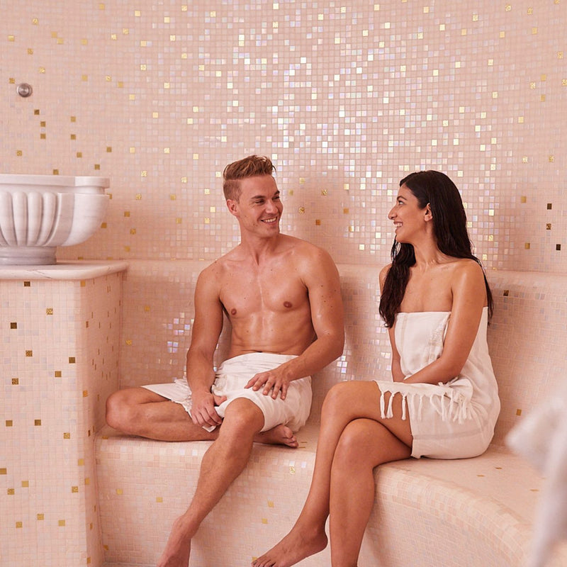 Paar genießt gemeinsam das Hamam im warmen Dampfbad – entspannte Atmosphäre bei „Les Perles“, dem orientalischen Partnerprogramm für zwei.