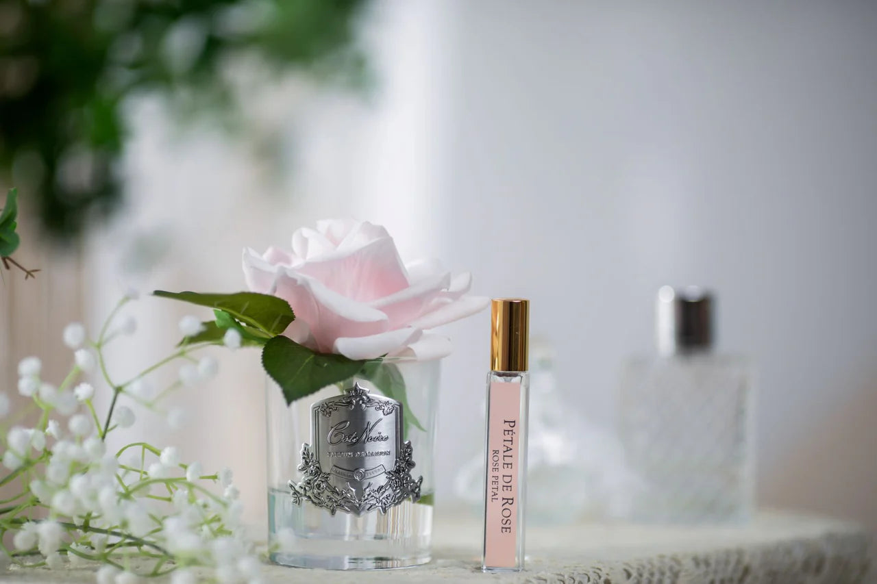Zartrosafarbene Duftblume im Glas mit Parfumflakon – edle künstliche Rose als romantische Dekoration für Schlafzimmer oder Badezimmer
