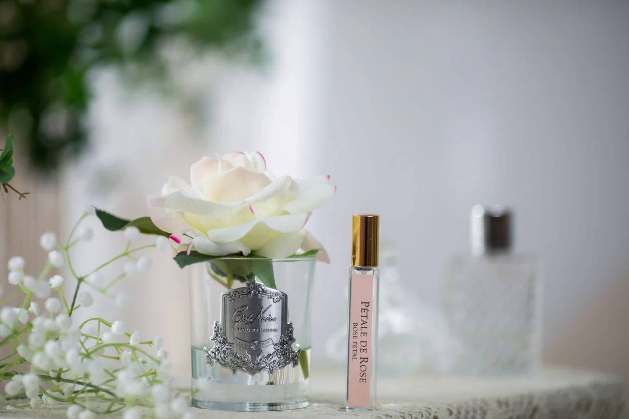 Luxuriöse Duftrose im Glas mit dezenten Rosatönen und Parfumflakon – elegante künstliche Duftblume als stilvolle Dekoration für Wohnzimmer oder Bad