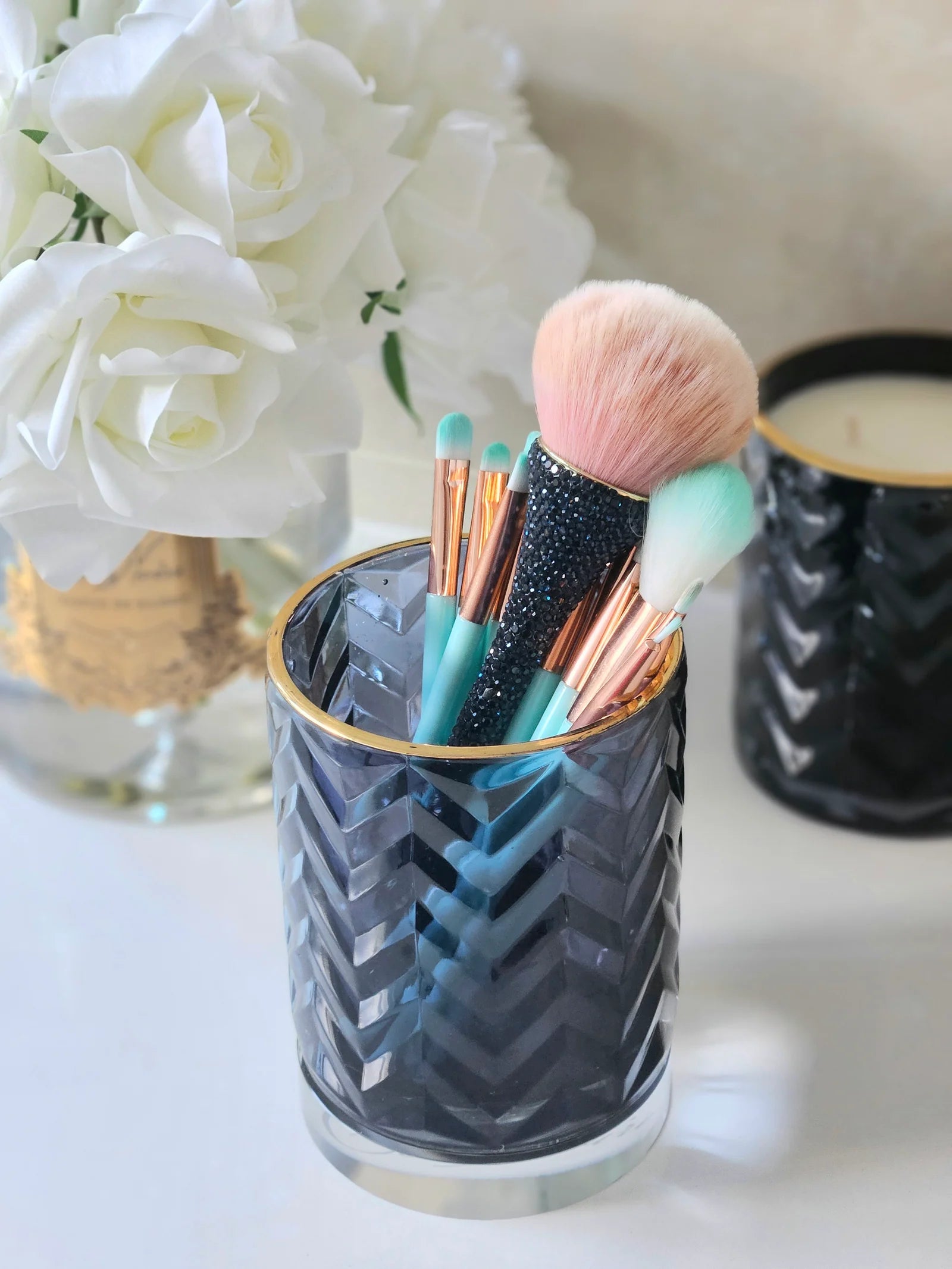 leeres herringbone glas als stilvoller behaelter fuer ein brush set.