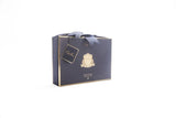 edle blau-goldene geschenkverpackung mit goldenem emblem und blauer schleife. weisser hintergrund.