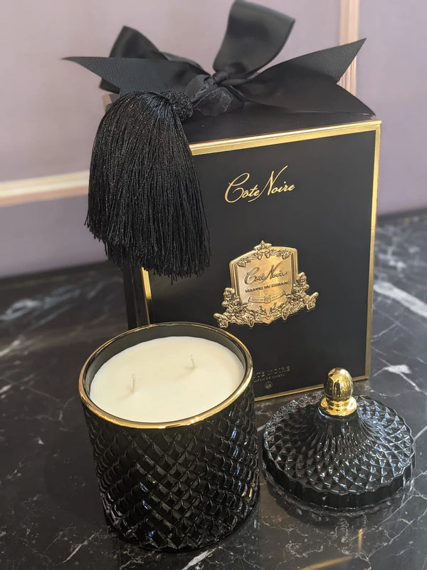 grand art duftkerze mit doppeldocht, dahinter geschenkbox mit schleife, schwarze und gold.