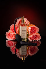 istanbul parfum 125ml glasflasche mit pumpspray vor einem strauss rosen in roser farbe