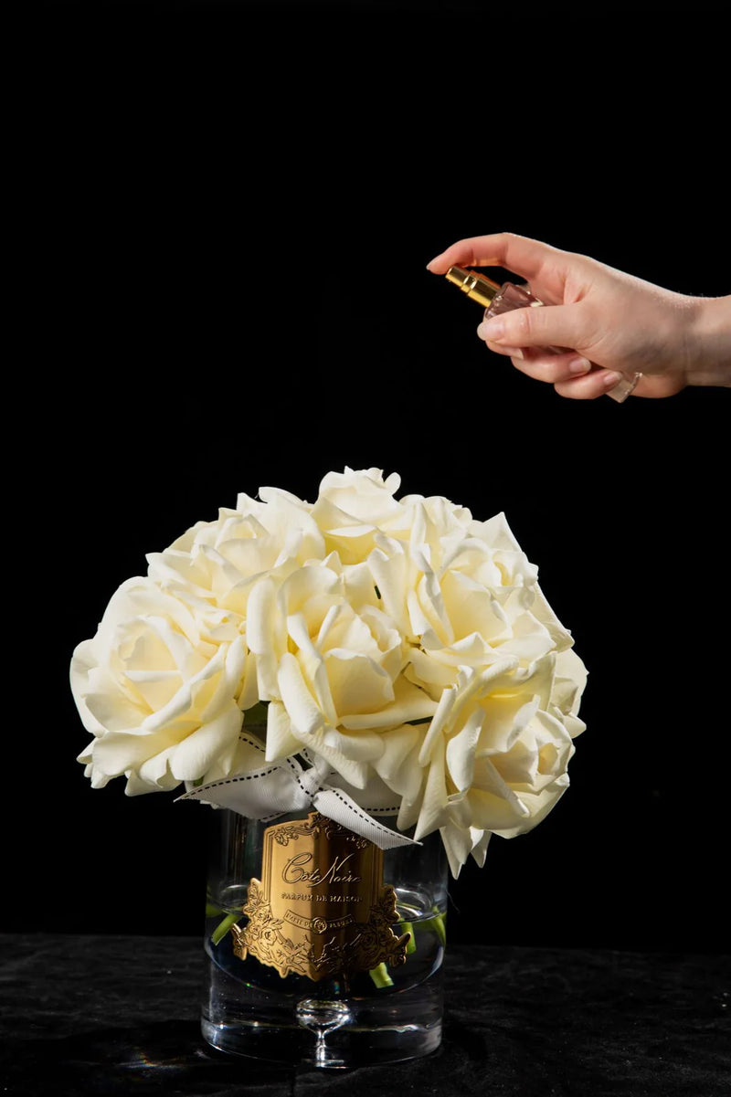 luxury grand bouquet duftblume wird mit einem duftspray besprueht. schwarzer hintergrund.