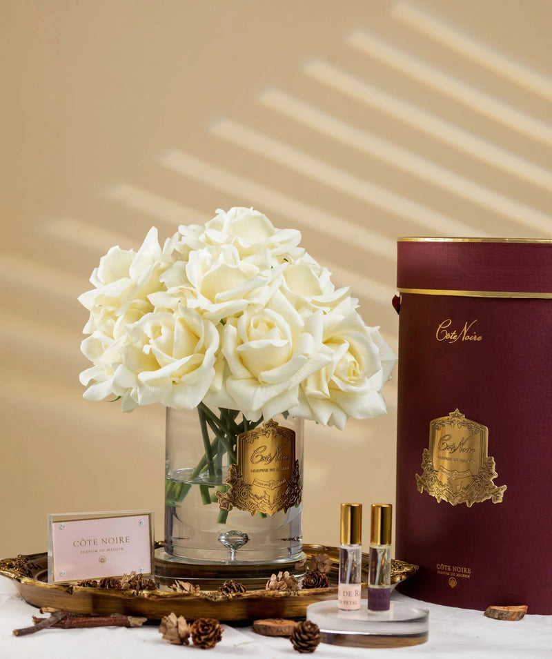 luxury grand bouquet duftblume mit cremeweißen rosen auf holztablett mit kiefernzapfen.