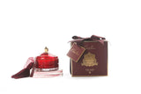 cote noire grand art duftkerze in dekorativem glas, daneben verpackung mit geschenkschleife, rot und gold.