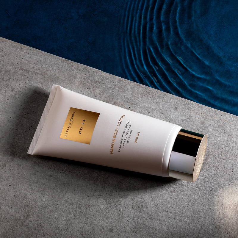 nr.94 koerperlotion weisse tube 200ml goldener aufdruck und goldene kappe auf grauem tisch mit blauem hintergrund