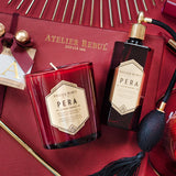 komplett in rot gehaltes bild auf der geschenkebox liegt die rote flasche duftkerze von pera sowie goldene Dekoelemente