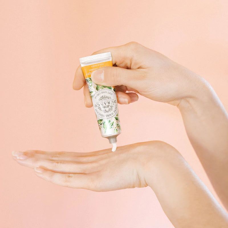 vor dem rosa hintergrund wird die creme aus der tube von einer hand gedrueckt creme landet auf dem handruecken