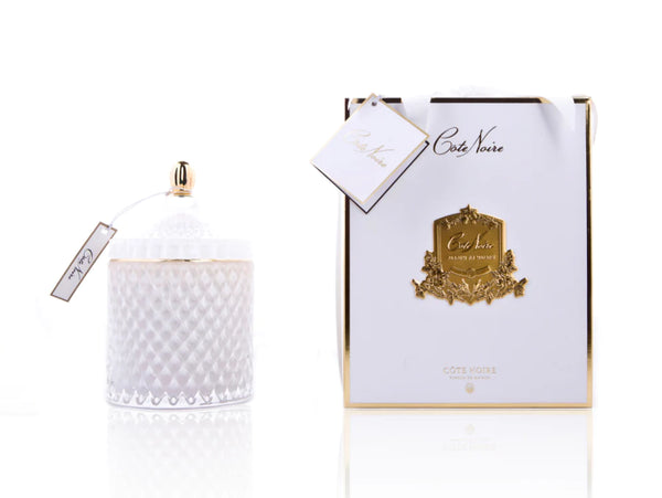 cote noire grand art duftkerze in dekorativem glas, daneben verpackung mit geschenkschleife, weiss und gold.